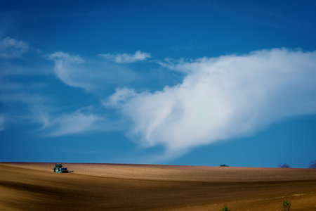 Work with an agricultural tractor in Moravian fields. A wonderful blue sky. Czech Republicの写真素材