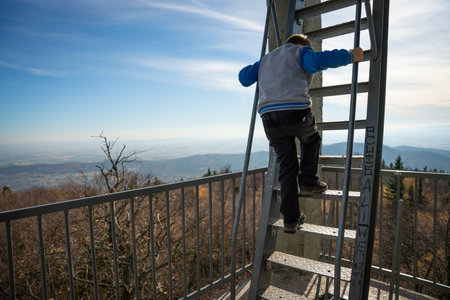 Little kid is going down the ladder of the dock tower. fall seasonの写真素材
