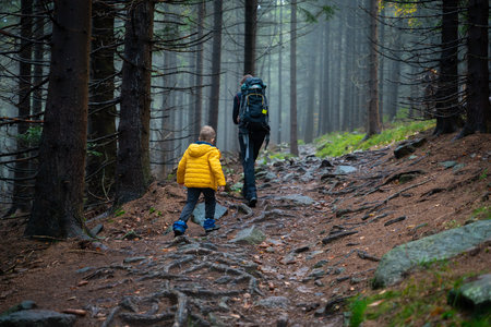 Mum and her little son go on a mountain trail in wet autumn weather. polish mountains