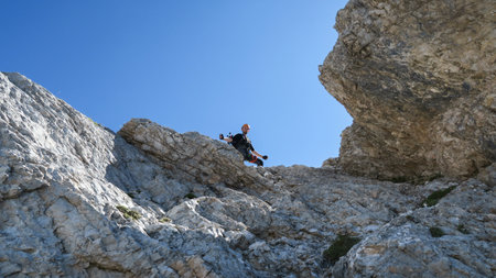 Tourist with equipment on a mountain trail in the Alps. Dolomites, Italy