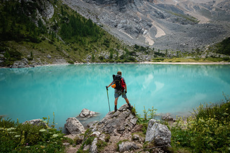 Tourist posing for a photo against the background of the beautiful Lago di Sorapis lake in the...
