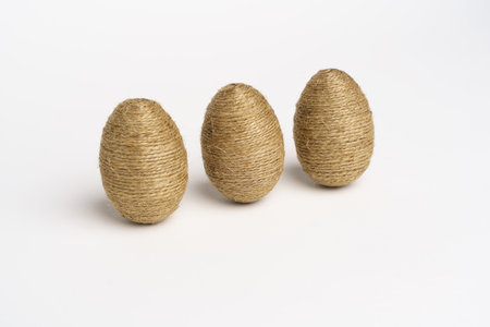 Hand wrapped easter eggs with jute twine, isolated white background. Studioの写真素材