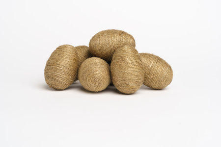 Hand wrapped easter eggs with jute twine, isolated white background. Studioの写真素材