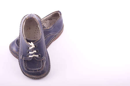 worn blue baby shoes isolated on whiteの写真素材