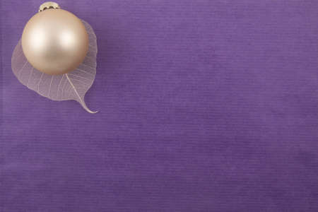 Christmas paper back ground purple and a golden ballの写真素材