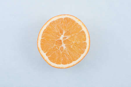 Orange fruit sliced open on bright blue colored paper