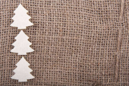 three white felt christmas trees on juteの写真素材