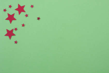 a diversity of red colored stars on green colored paperの写真素材