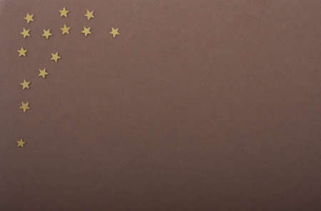 a diversity of gold colored stars on brown colored paperの写真素材