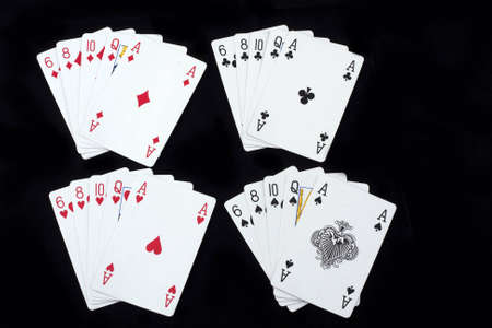 4 combinations of winning poker hands in spades, clubs, diamonds and hearts in a flush, isolated on blackのeditorial素材