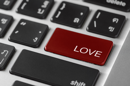 computer notebook keyboard selected focus on  red enter button with word Loveの写真素材
