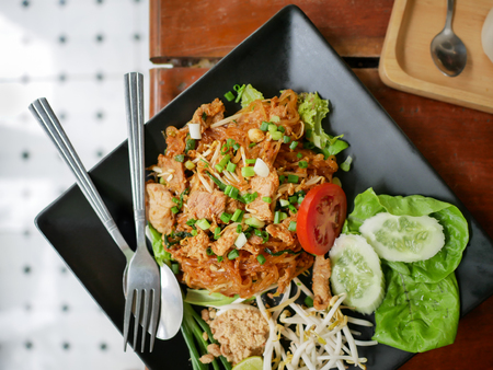 Top view closeup of Phadthai, Favorite popular thai noodle food with vegetables side dishes on black plateの写真素材