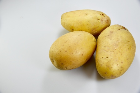 the three potatoes over the white backgroundの写真素材