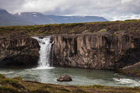 Small waterfall flows into the lake, Icelandの写真素材