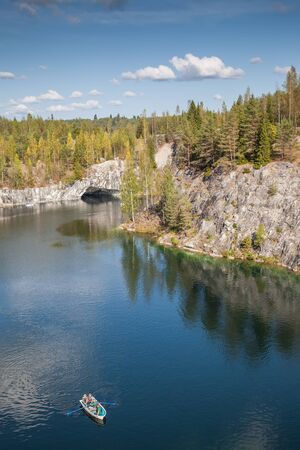 Boat with tourists sailing on the lake in the mountains of marbleの写真素材