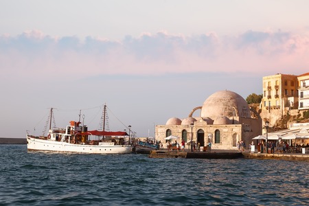 CRETE,  GREECE - JULY 22, 2015:  Venetian harbor of Chania with the Janissaries Mosque (XVII century) and pleasure boat with touristsのeditorial素材