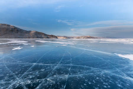 Frozen Lake Baikal. Blue ice with cracks near Olkhon Island, winter landscape.の写真素材