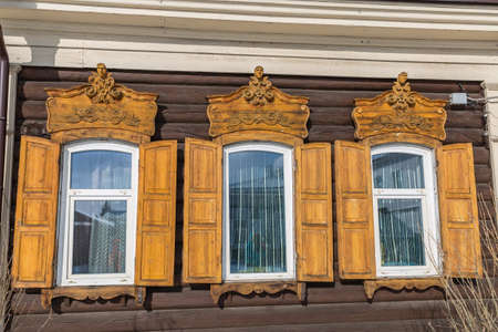 Window with the wooden carved architrave in the old wooden house in the old town Ulan-Udeの写真素材