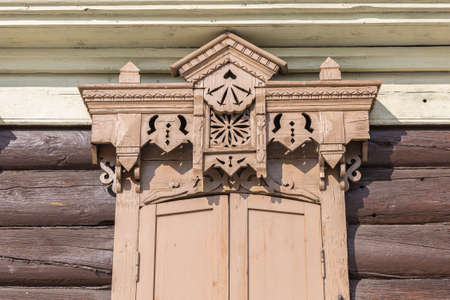 Window with the wooden carved architrave in the old wooden house in the old town Ulan-Udeの写真素材