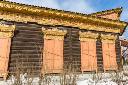 Window with the wooden carved architrave in the old wooden house in the old town Ulan-Udeの写真素材