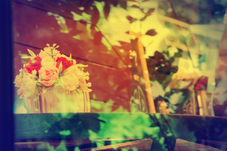 Vase of flowers in vintage style through cafe's glassの写真素材