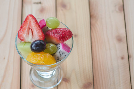 mixed fruit in glass on wood table, healthy foodの写真素材