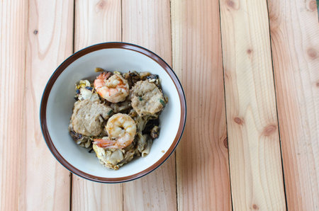 Mixed fried noodle with shrimp and pork on wood tableの写真素材