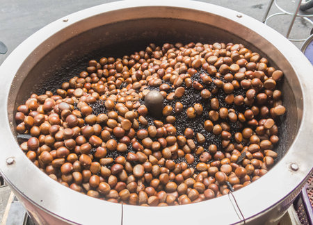 Roasting chestnut in rotary machine at Bangkok chinatown market, Thailand. street foodの写真素材