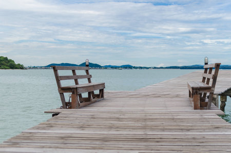 Bench on wooden bridge to the seaの写真素材