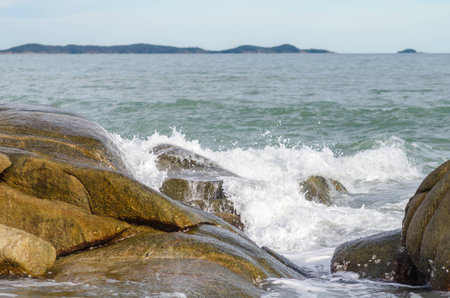 Wave crashing on rock beachの写真素材