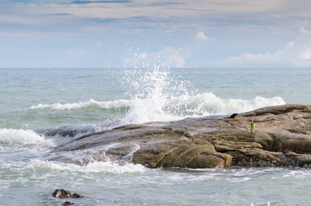 Wave crashing on rock beachの写真素材