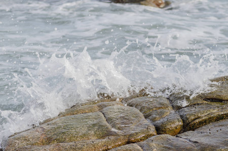 Wave crashing on rock beachの写真素材