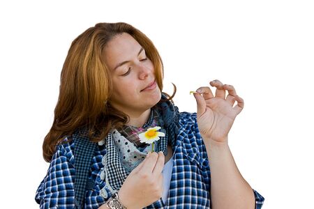 woman detaching petals on a flowerの写真素材
