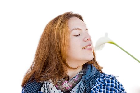 Beautiful woman portrait smelling a flowerの写真素材