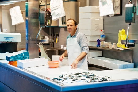 MALAGA, SPAIN - MARCH 31: An unidentified seller packs the fishes at his shop in the popular central market on March 31, 2012 in Malaga, Spain.It was renovated in 2010 and it was reopened on March 2011.  のeditorial素材