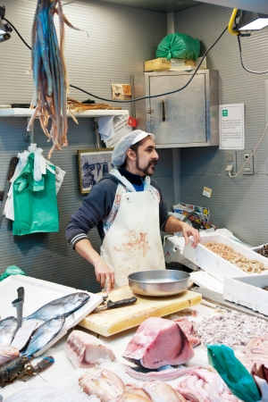 MALAGA, SPAIN - MARCH 31: An unidentified seller packs the fishes at his shop in the popular central market on March 31, 2012 in Malaga, Spain.It was renovated in 2010 and it was reopened on March 2011.  のeditorial素材