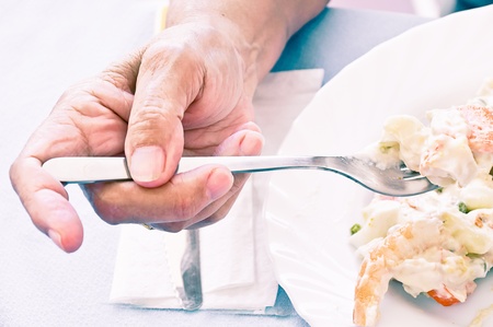 old woman eating russian saladの写真素材