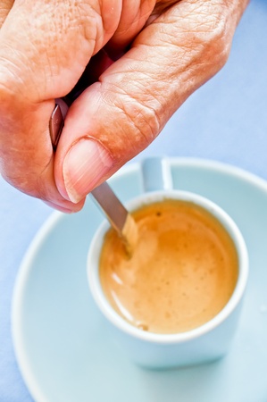 old woman taking a cup of coffeeの写真素材