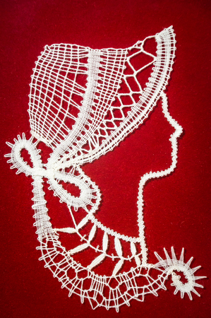 White handmade lace on red backgroundの写真素材