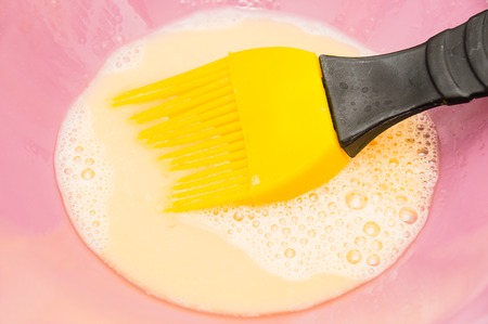 Using yellow silicon brush utensil for baking の写真素材