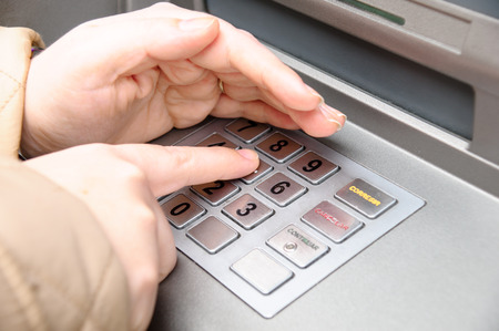 woman hand entering pin code in a ATMの写真素材