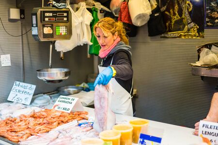 MALAGA, SPAIN - JANUARY 16: A woman working with fish at central market on January 16 in Malaga,Spain.のeditorial素材