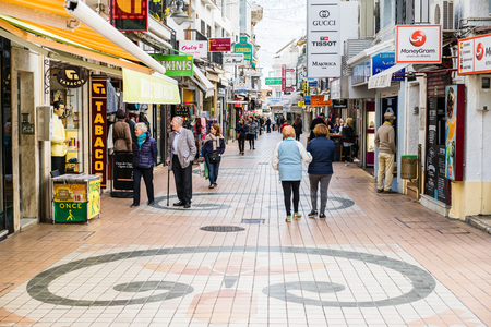 TORREMOLINOS, SPAIN - JANUARY 21: Sidewalk with different shops and many tourists walking on January 21 in Torremolinos, Spainのeditorial素材