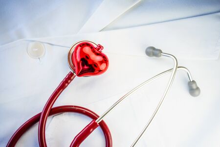 Stethoscope and decorative red heart on white doctor's overall
