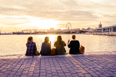 MALAGA, SPAIN - JANUARY 23: girls sitting on seafront at sunlight on January 23 in Malaga, Spain.のeditorial素材