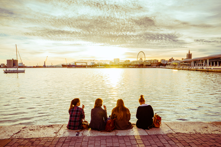MALAGA, SPAIN - JANUARY 23: girls sitting on seafront at sunlight on January 23 in Malaga, Spain.のeditorial素材