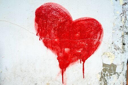Red painted heart on blue cracked wallの写真素材