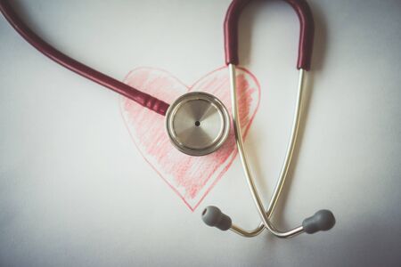 Close-up of painted heart and stethoscope on white backgroundの写真素材