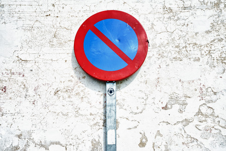 Round road sign of prohibited parking against of white cracked wallの写真素材