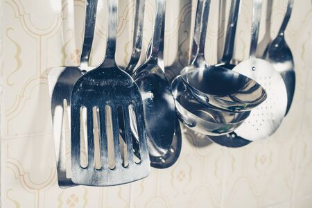 Metal kitchenware hanging on wall in close-up